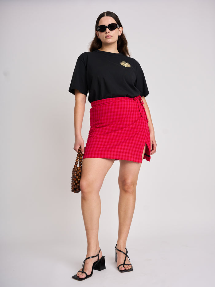 The Lucie Marquis 'Edie Mini Sarong', a versatile wrap skirt inspired by the iconic style of Edie Sedgwick from the swinging 60s. This mini sarong transitions effortlessly from day to night, making it ideal for all travel adventures - perfect for sun-kissed days at the beach or city evenings. Pair it with a tank top or t-shirt for a casual look, or dress it up with heels for a party-ready look.